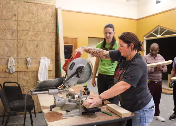 two people working with a saw